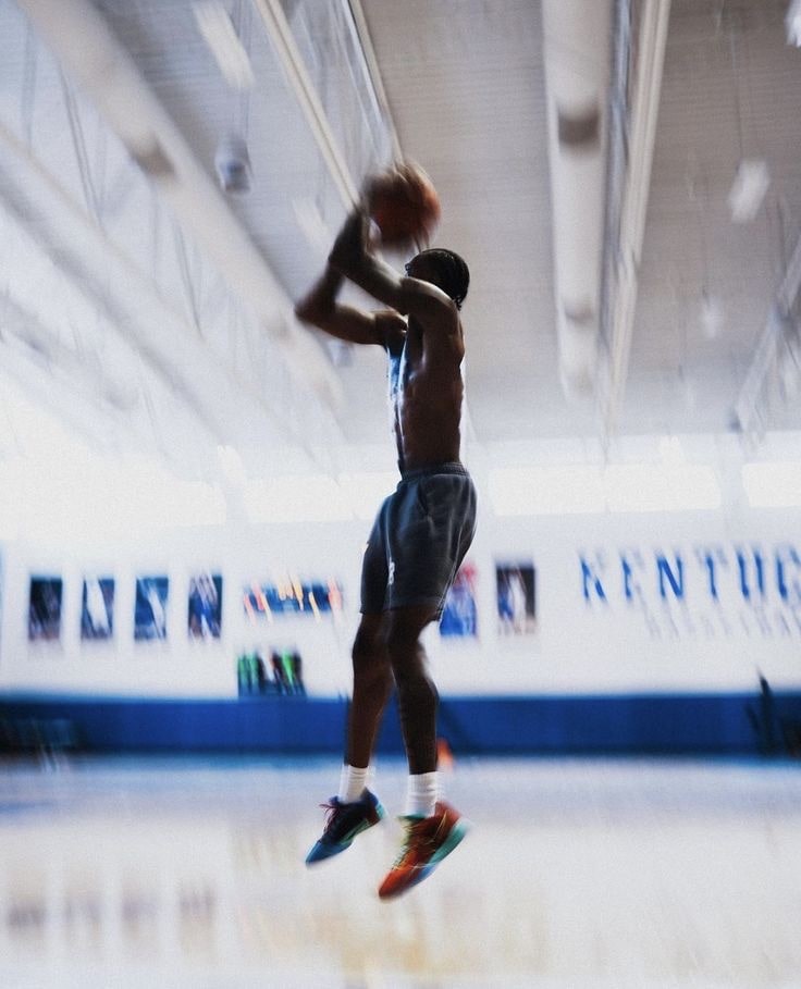joueur de basket tirant en suspension avec un ballon TechBall dans un gymnase avec un effet flou