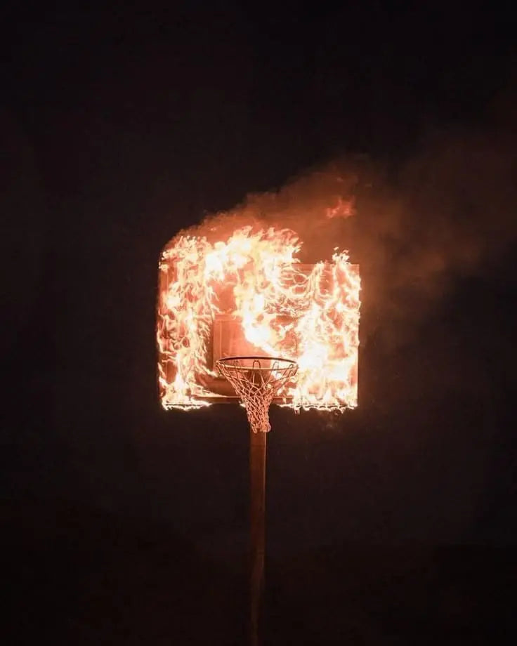 panier de basket en flammes la nuit, symbole d'intensité et de progression au basket grâce à l'IA TechBall